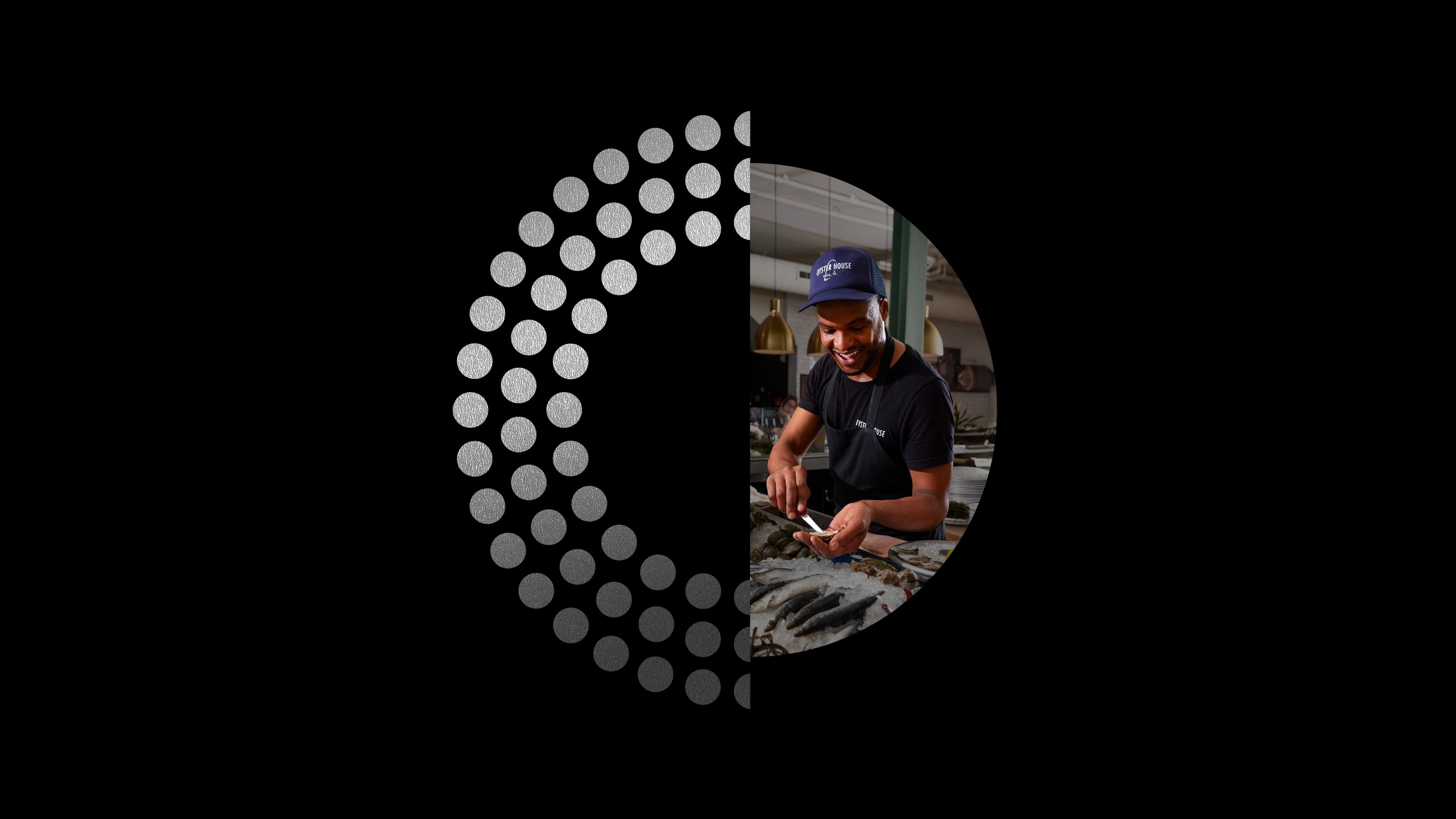 Half circle of three-layered silver foil medallions, and a half circle of a picture of a man shucking oysters at Oyster House in Philadelphia