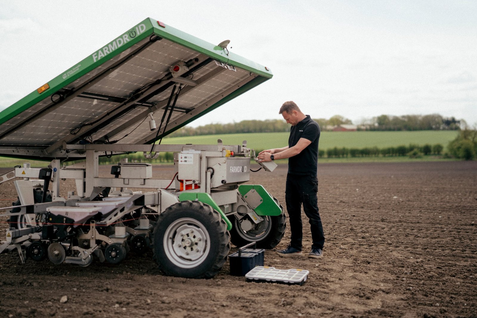 FarmDroid-medarbejder arbejder med automatiseret landbrugsmaskine på mark.