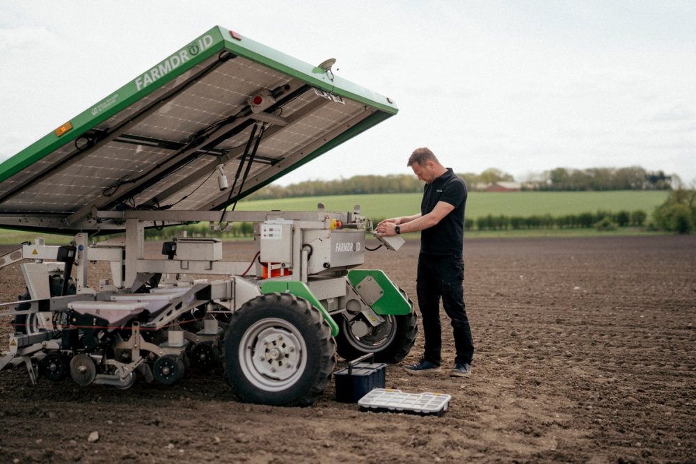 FarmDroid-medarbejder arbejder med automatiseret landbrugsmaskine på mark.