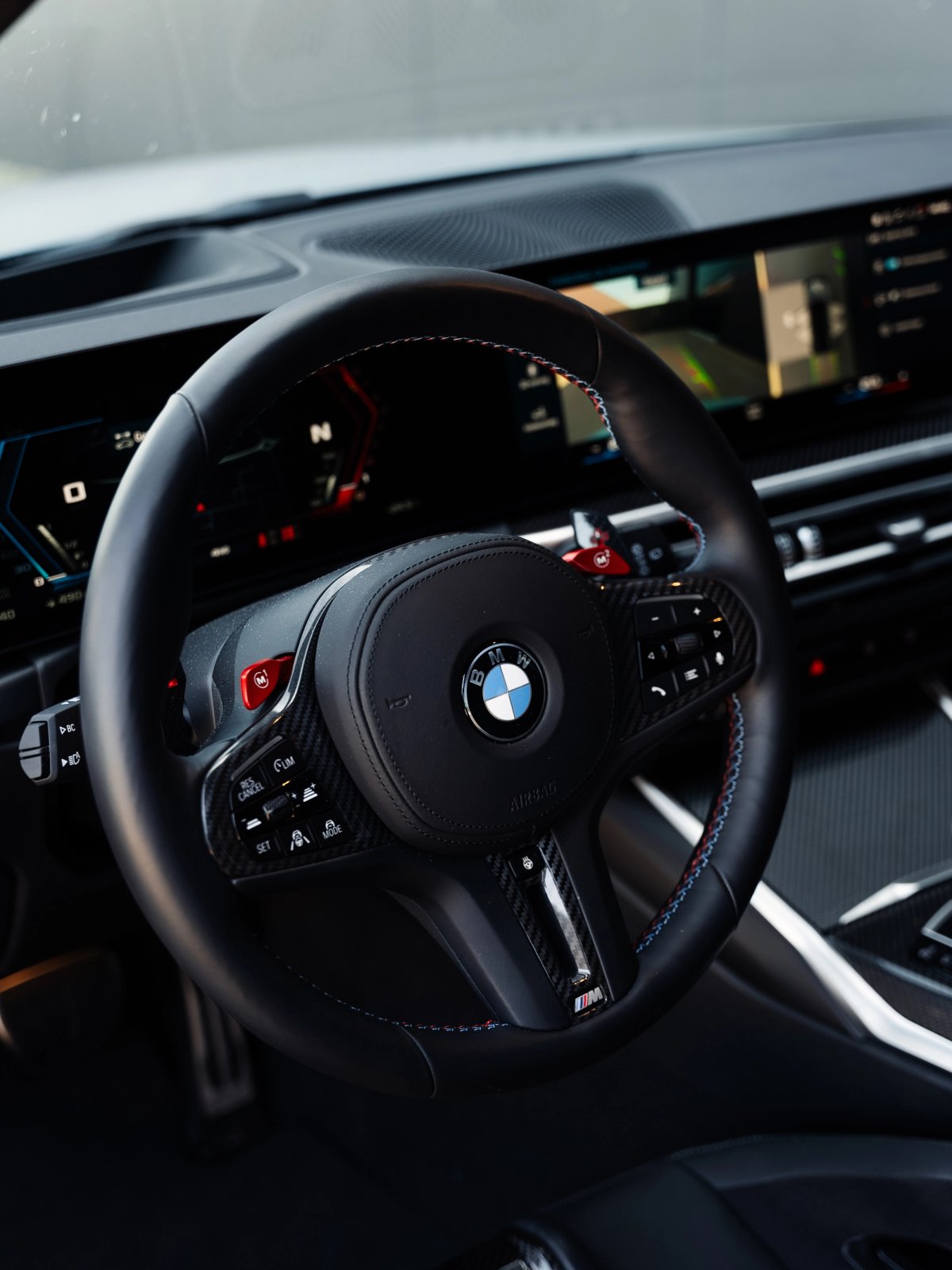 BMW M3 cockpit med digital instrumentering og sportsrat.