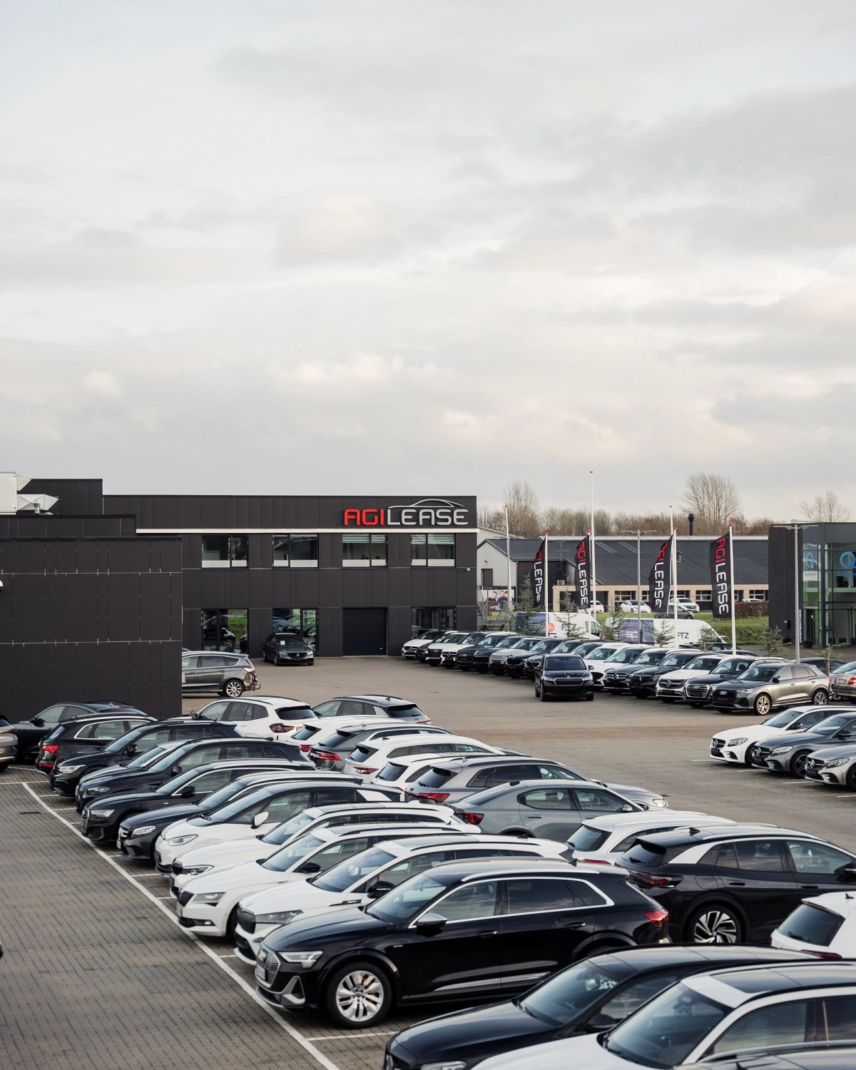 Administrationsbygningen hos Agilease med parkerede leasingbiler foran hovedkontoret