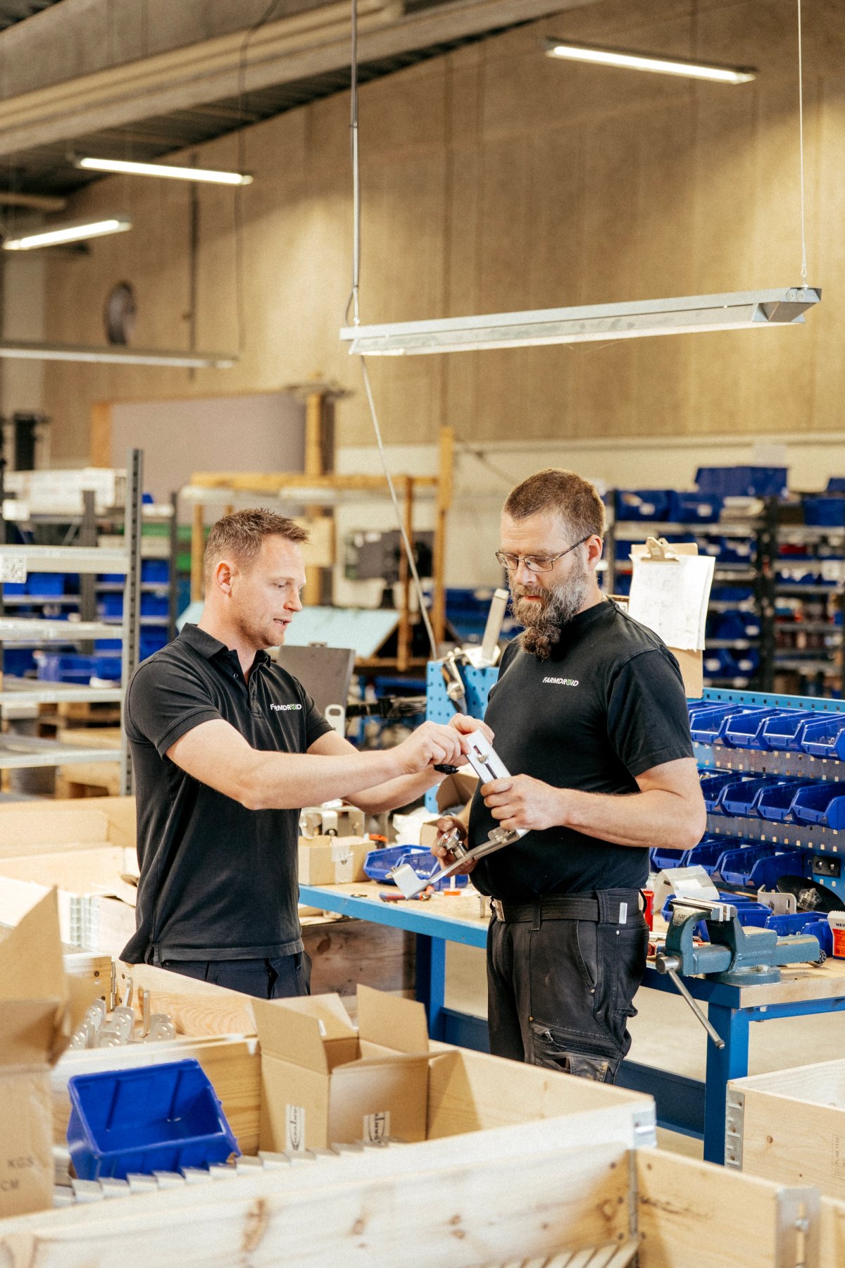 Medarbejdere samarbejder i FarmDroids produktionsmiljø