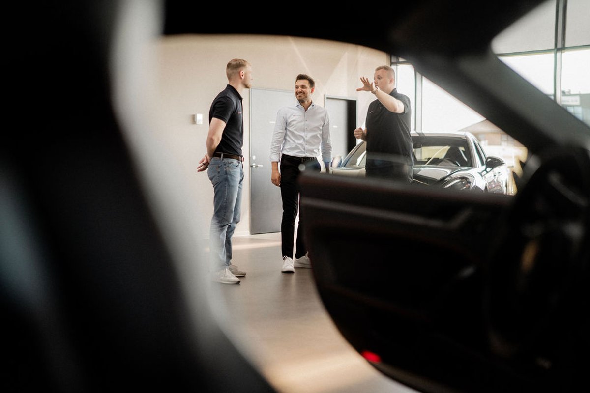 Leasingrådgivere taler sammen i Agileases showroom blandt leasingbiler og firmabiler.