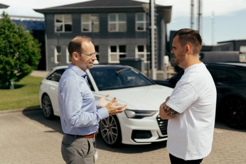 Thomas Bonnichsen, CCO hos Priess, taler med Agileases leasingrådgiver Ken Jensen om virksomhedens firmabil ved en Audi.