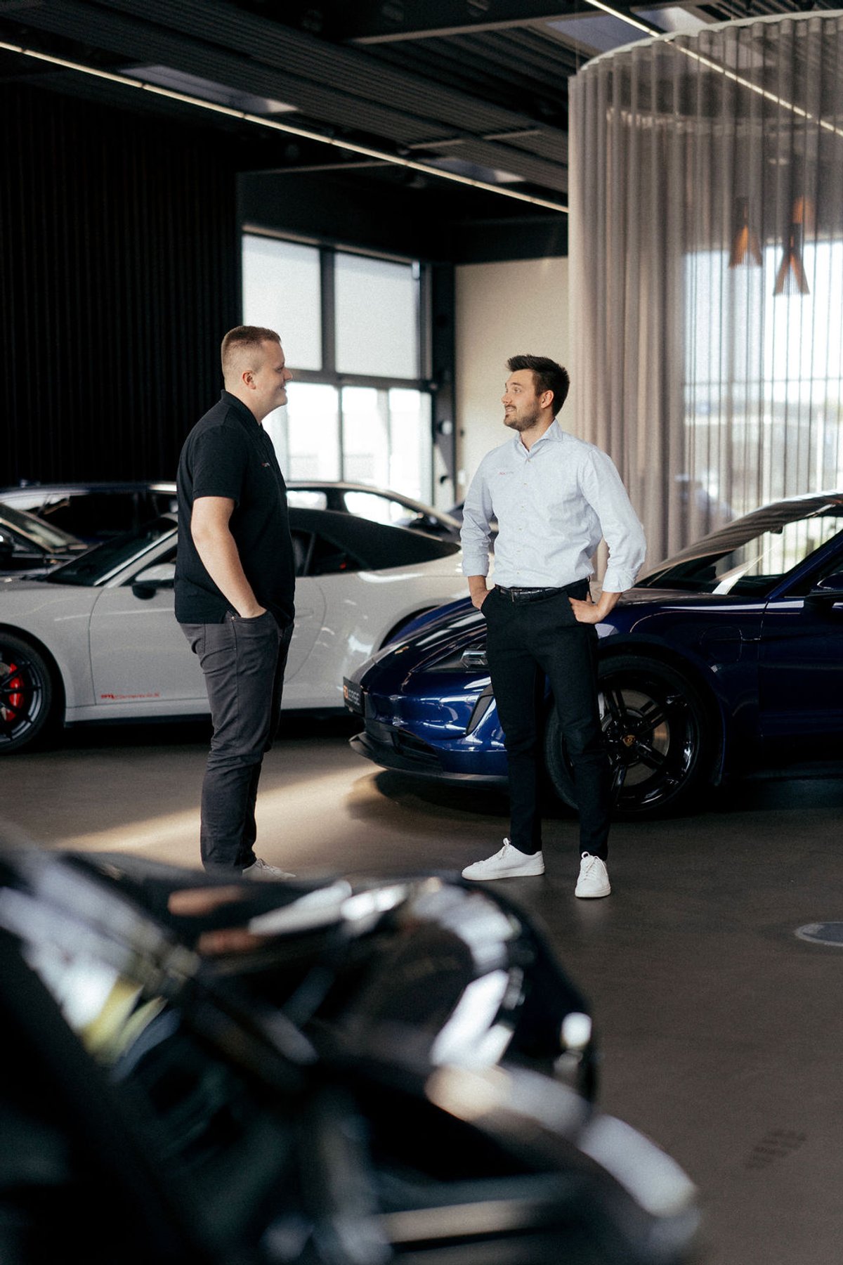 Leasingrådgivere taler sammen blandt biler i Agileases showroom.