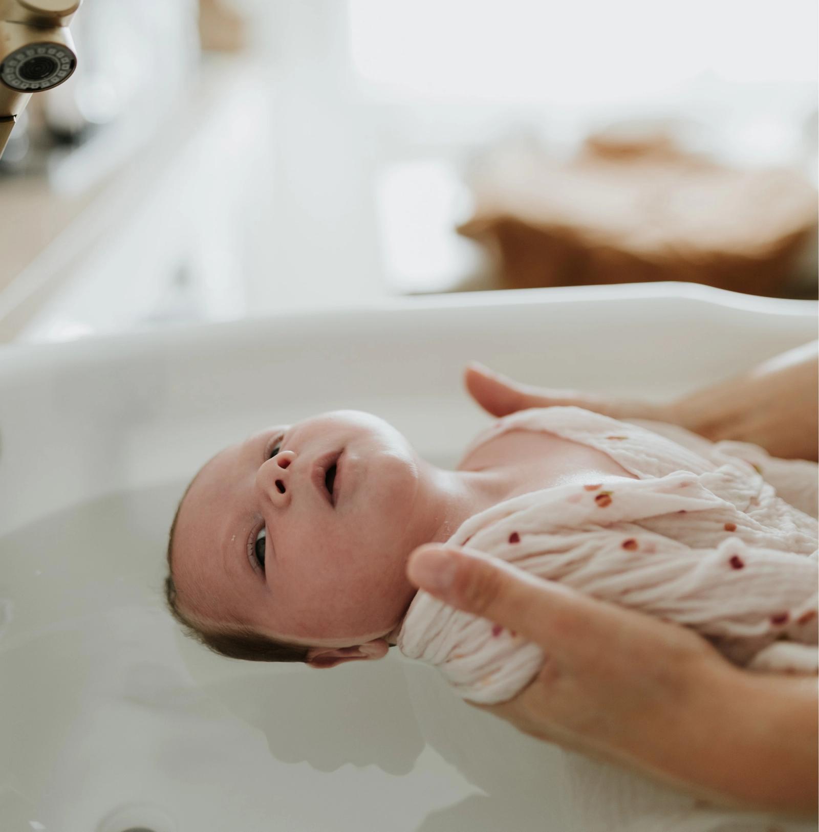 Nouveau-né apaisé pendant un bain thérapeutique