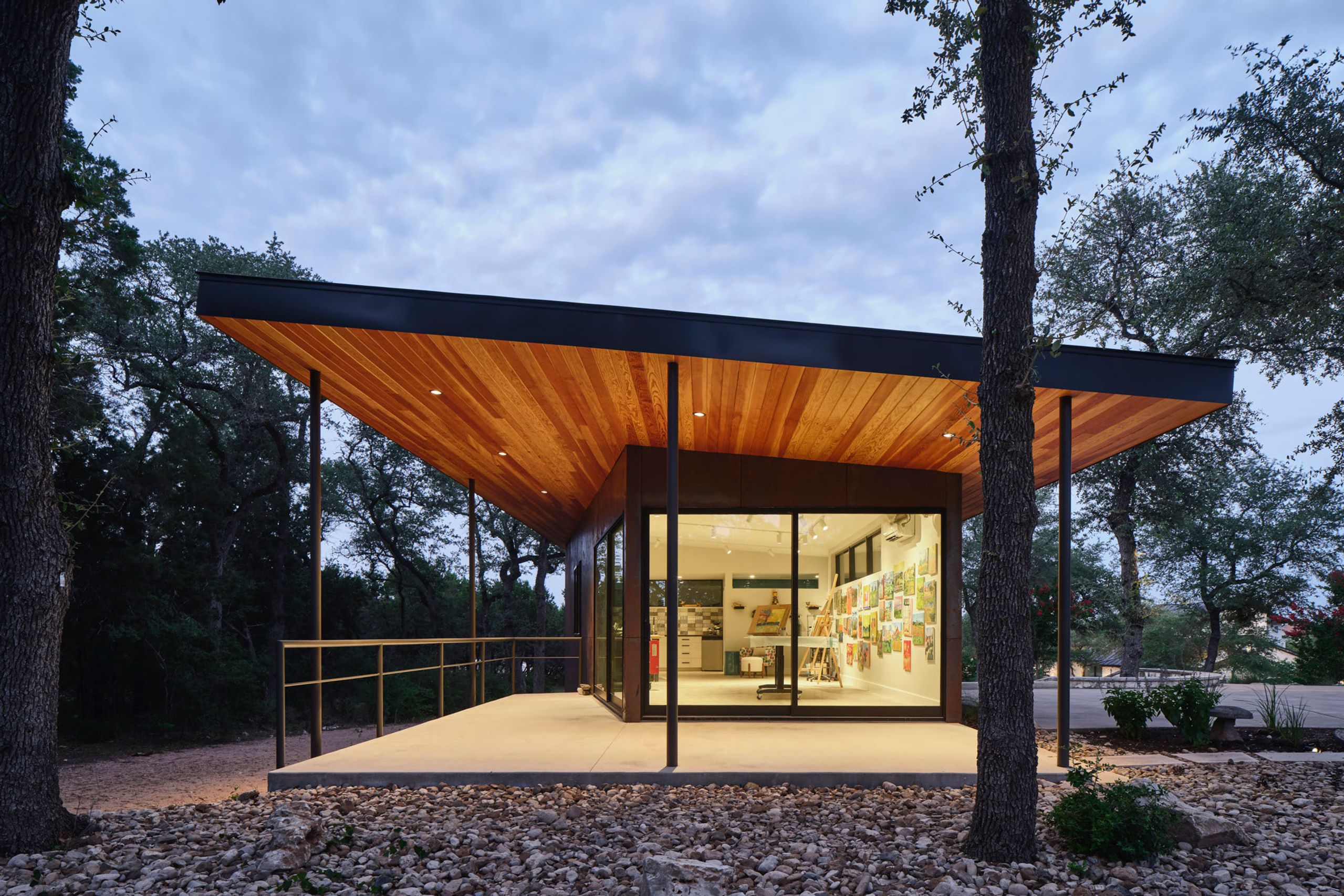 Small studio at dusk under a wide wood-lined roof