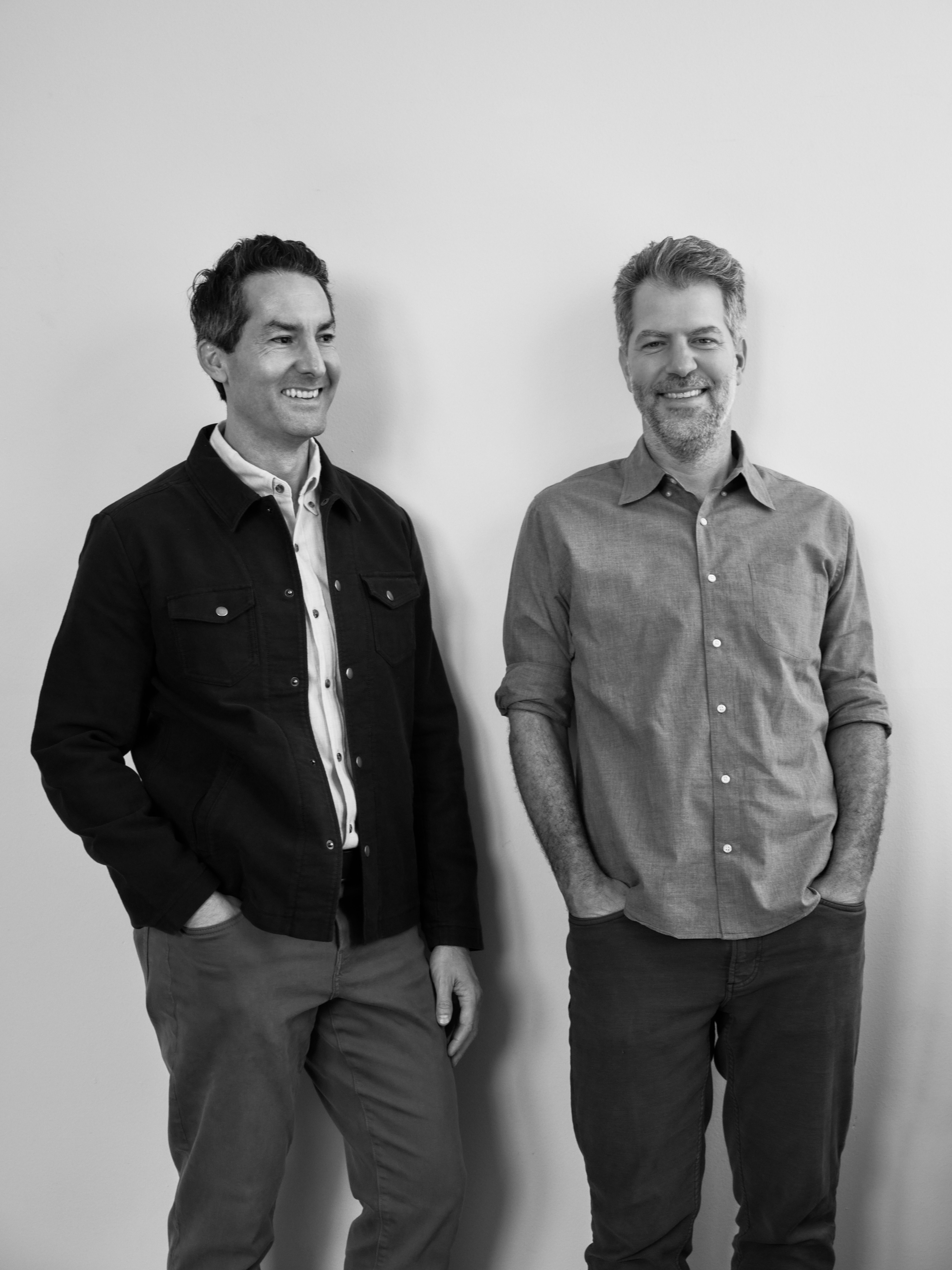 Joel Nolan and Andrew Bell, co-founders of Nolan Bell, standing against a white wall.
