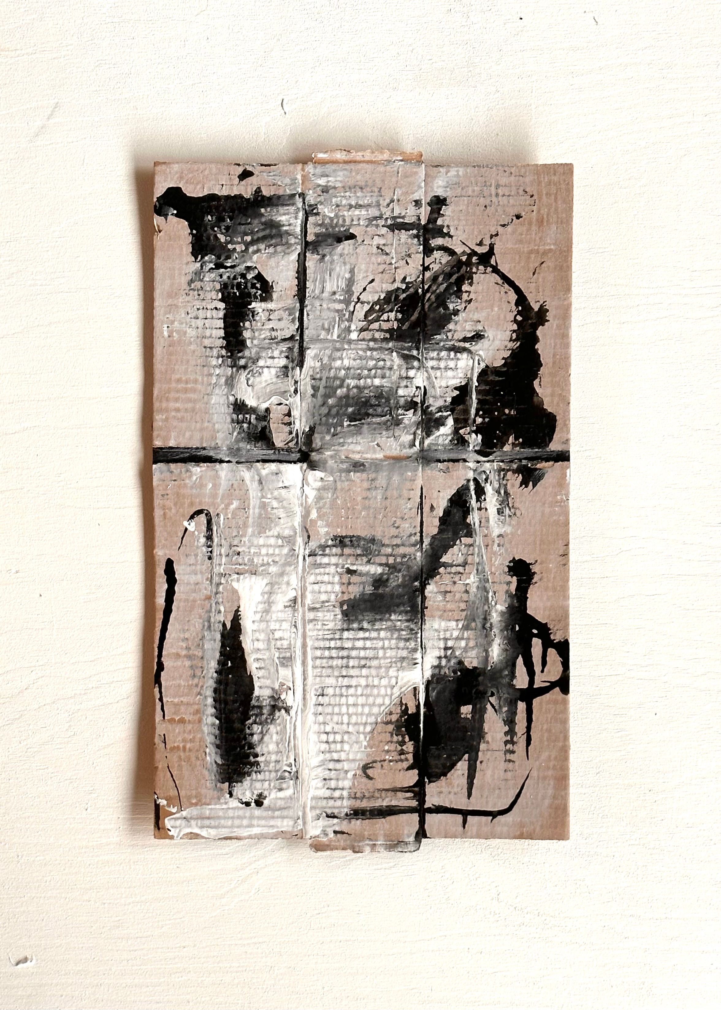 Sorte linjer og strøk danner figurliknende motiv på delvis hvit og bølgepapp bakgrunn 