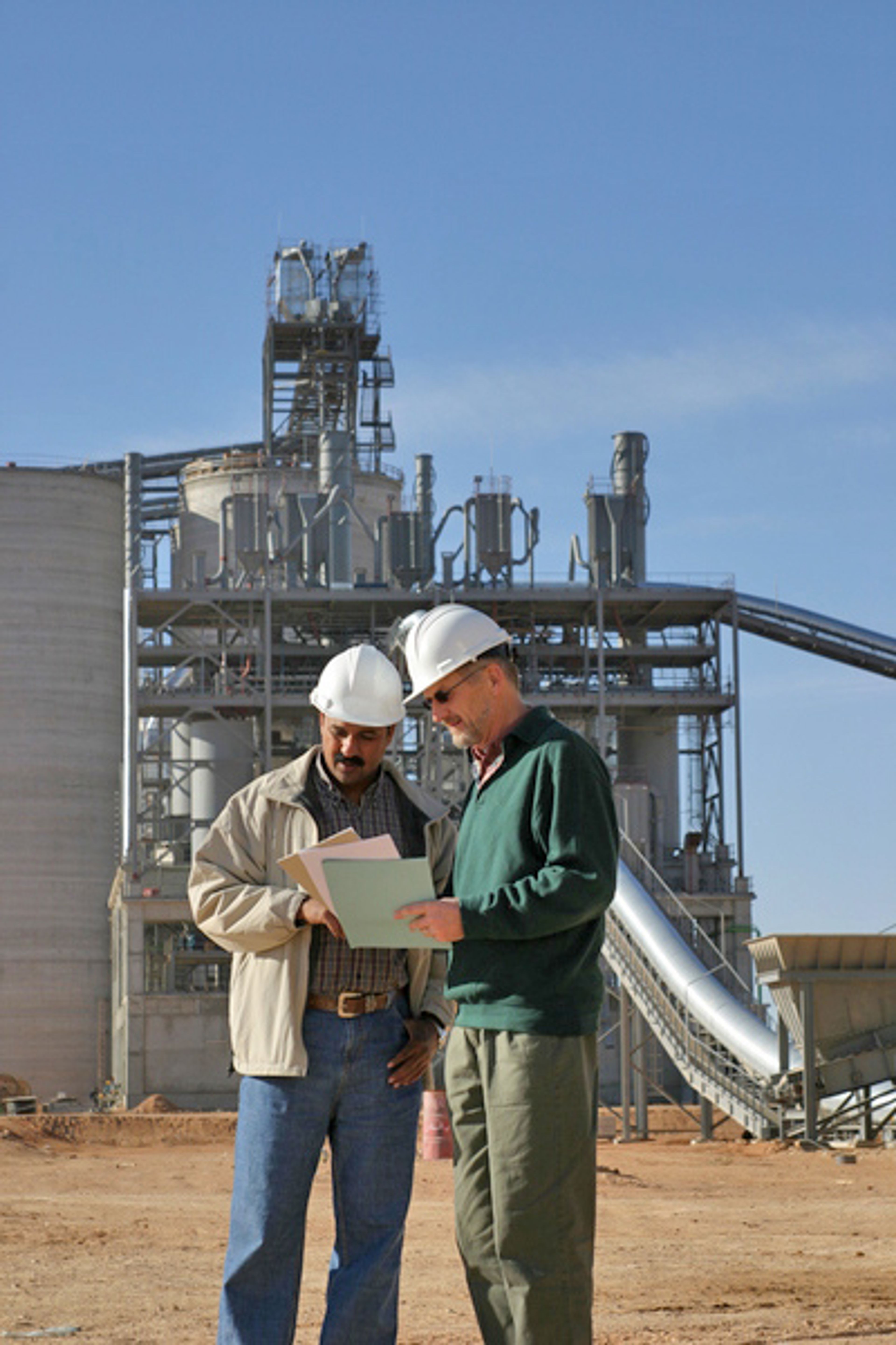 two people with helmet before a plant