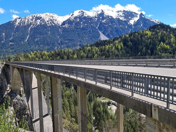 Gamstalbrücke mit verschneiten Berggipfeln und blauem Himmel