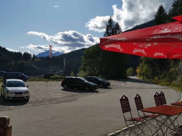 Parkplatz des Gaichtpassstüberl mit Autos und Bergen im Hintergrund