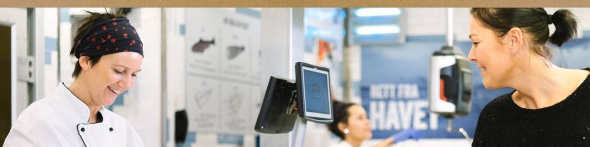 Matarbeider hjelper en kunde i ferskvaredisken.