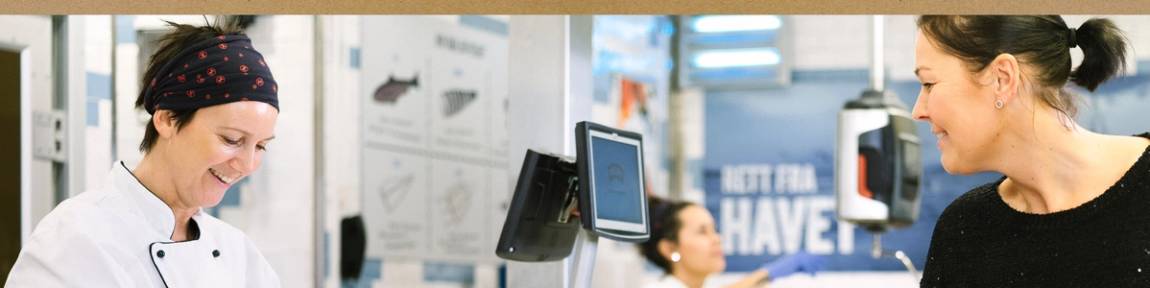 Matarbeider hjelper en kunde i ferskvaredisken.