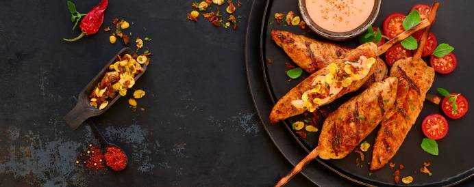 Kyllingfilet med paprika og grønnsaker på en tallerken, servert med en saus ved siden av.