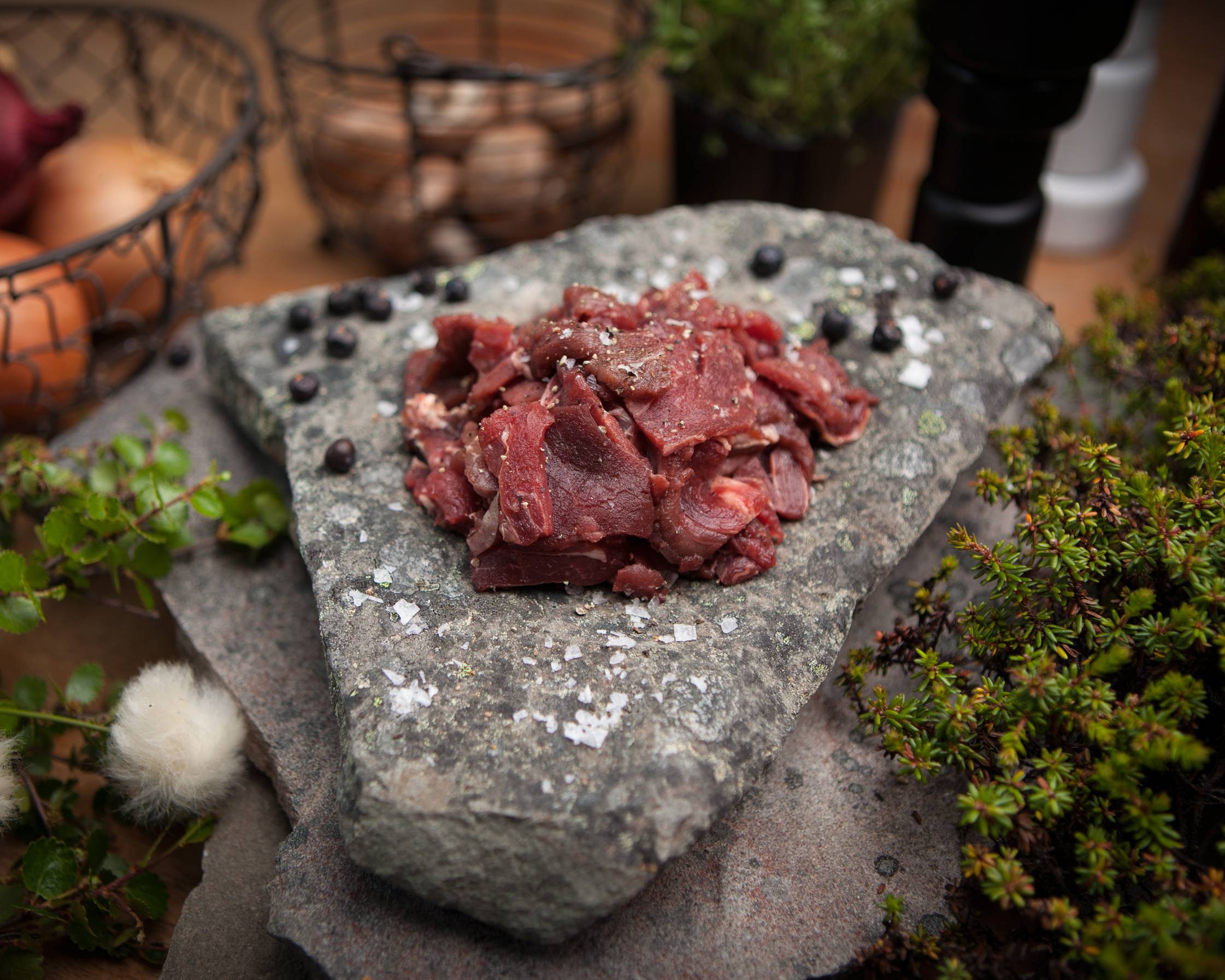 Reinskav lagt på en stor stein, omgitt av planter og dekorative elementer, med en bakgrunn av innendørs miljø.