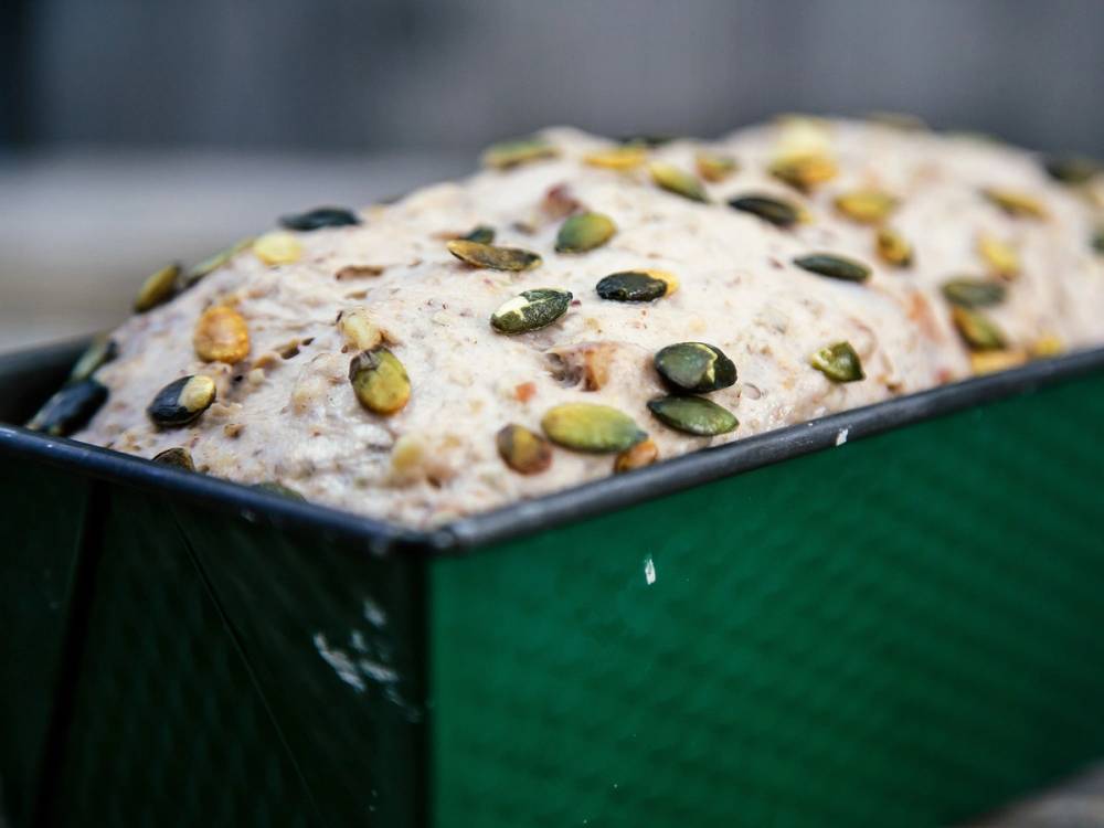 Grovbrøddeig med nøtter i en brødform før steking