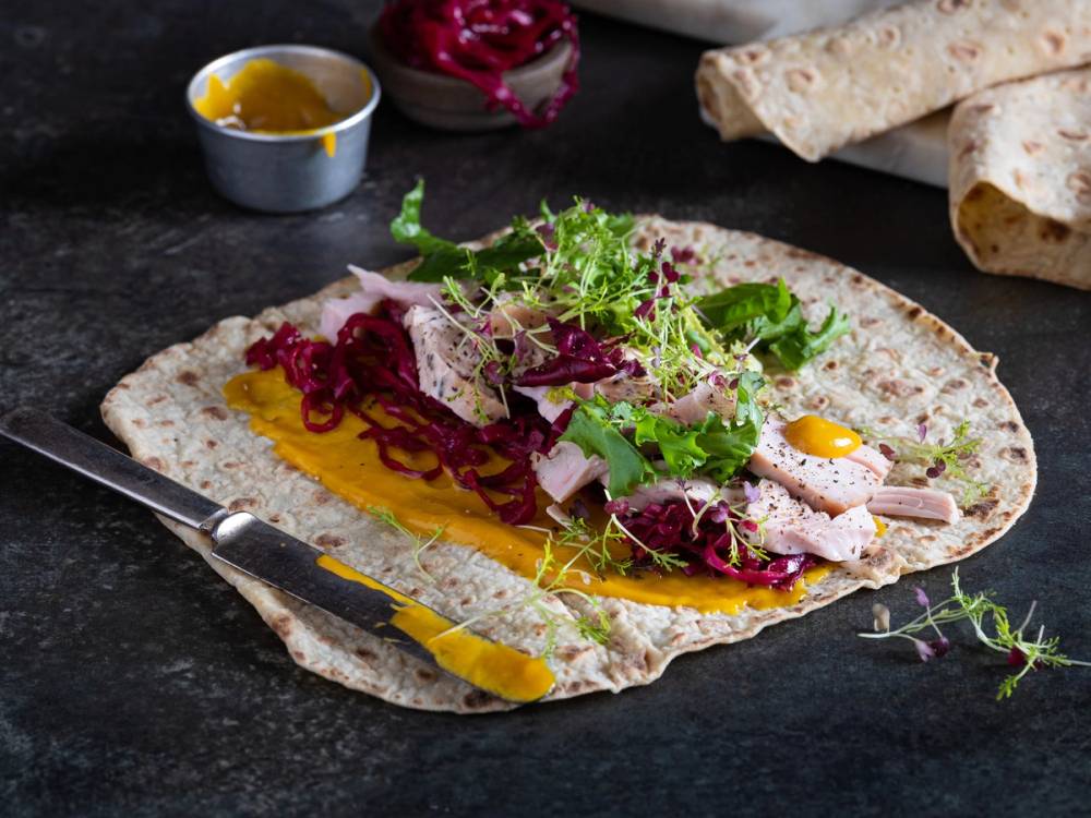 Restemat fra julefeiring med flatbrød, pålegg, salat og en liten skål med saus eller dressing.