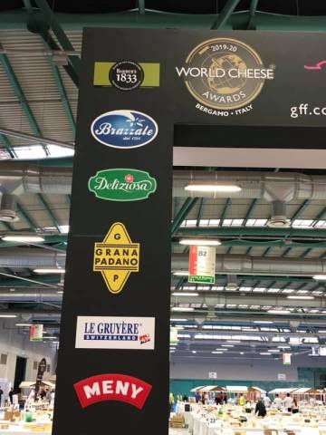 Skilt med logoer for ulike osteprodusenter og World Cheese Awards 2019-20 i Bergamo, Italia.