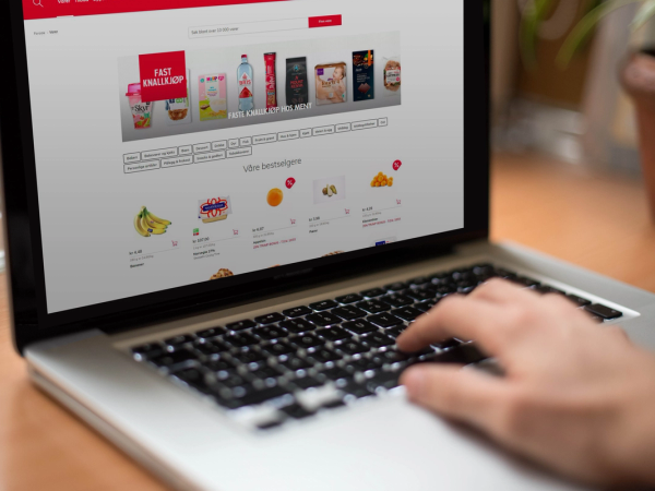 Nærbilde av en person som handler i en nettbutikk på en bærbar datamaskin, med produktbilder og bestillingsknapper på skjermen.