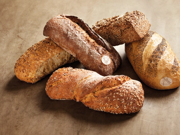 Ulike typer brød og kaker ligger på et bord.