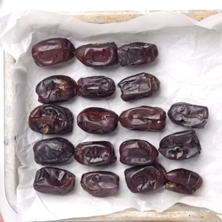 Daddel på et fat, plassert på et hvitt papirark.