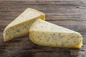 To stykker blåmuggost på en treplate, med en lys gul farge og blå muggsporer.