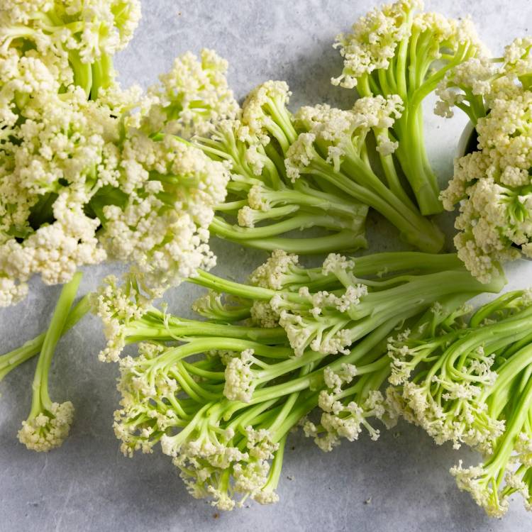 Flere buketter med blomkål som ligger på en grå overflate.