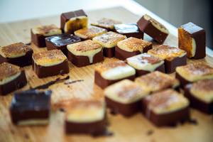 Ulike sjokoladekaker med ulike toppinger ligger på et trebrett.