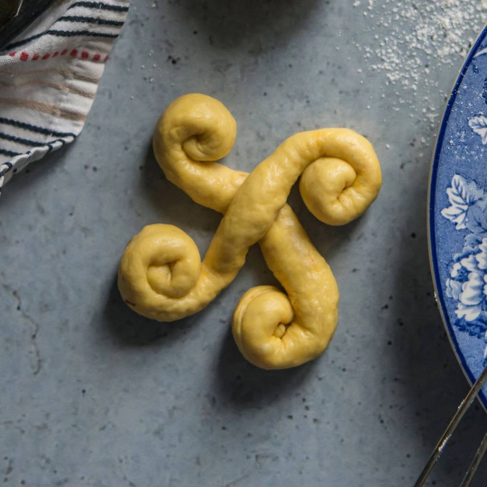 Lussekatt formet som en gullvogn på en kvadratisk tallerken