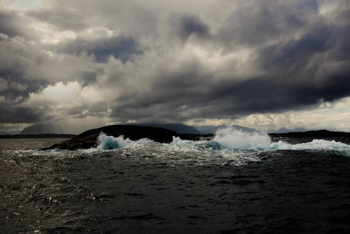 Havet med store bølger under en mørk, overskyet himmel.