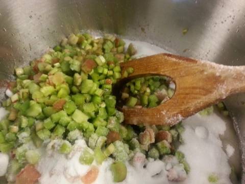 Løk og selleri hakkes i en stor gryte med en tresleiv som rører i grønnsakene.