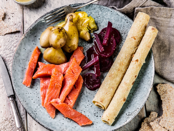 Rakfisk servert med rødløk og flatbrød på en tallerken