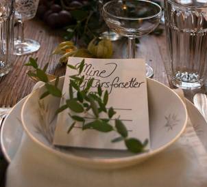 En bordsetting med et kort og grønt tilbehør, sannsynligvis til festlig anledning.