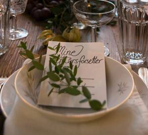 En bordsetting med et kort og grønt tilbehør, sannsynligvis til festlig anledning.