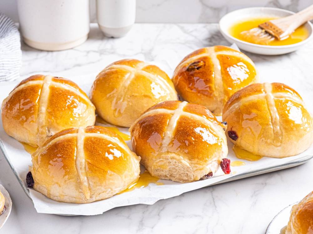Seks nystekte hot cross buns på et fat.
