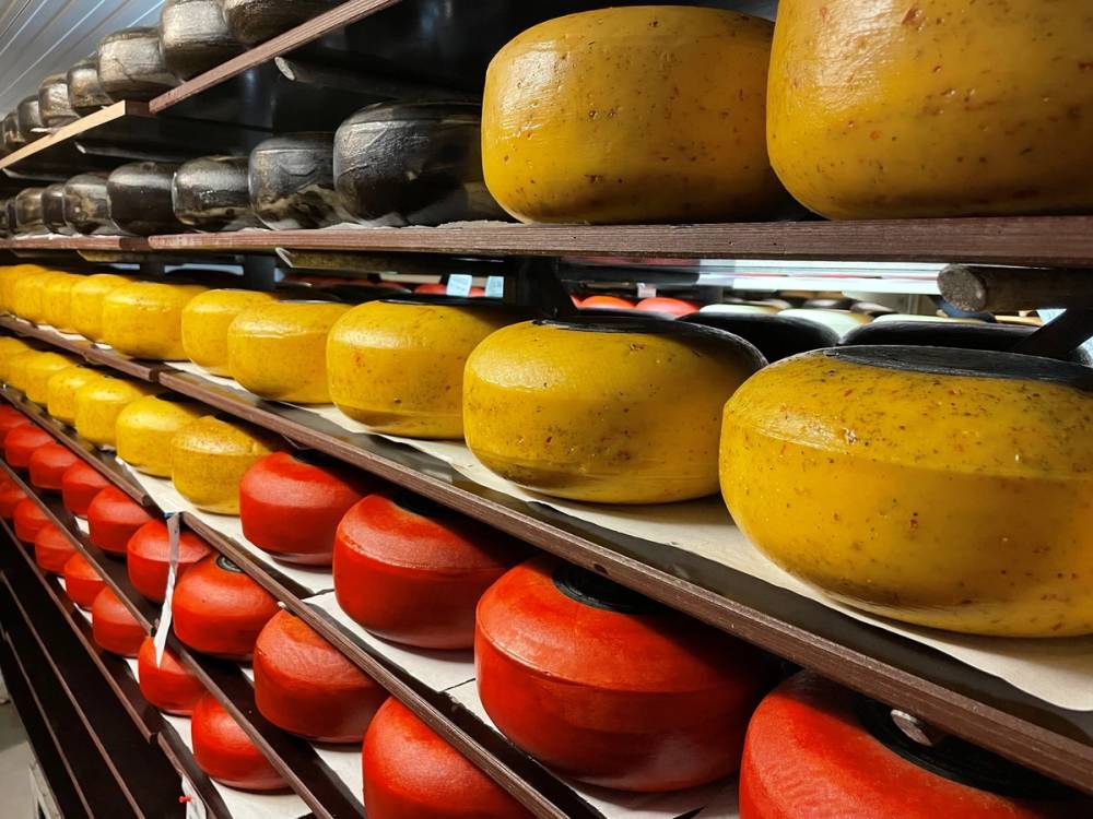 Ost i ulike farger og størrelser på lagerhyller i en butikk