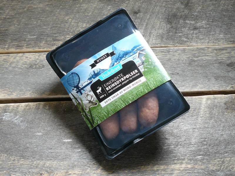 En liten svart boks med etikett som viser Thulefjord, plassert på en treoverflate.