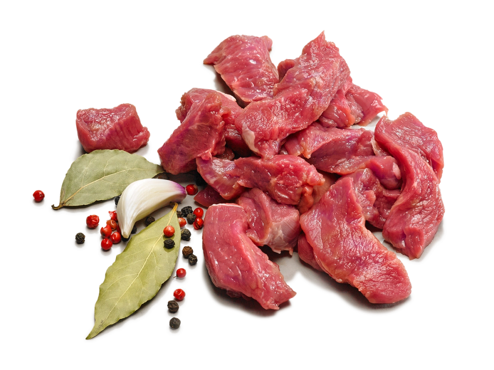 Skiver av benfritt lammekjøtt med noen krydderurter og pepperkorn ved siden av.