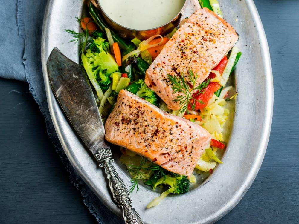 Grillet laks med poteter og grønnsaker på en oval tallerken.