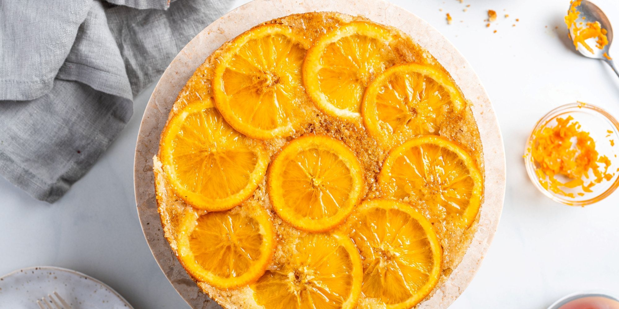 Appelsinkake med skiver av appelsin på toppen, opp ned, på en rund kakebunn.