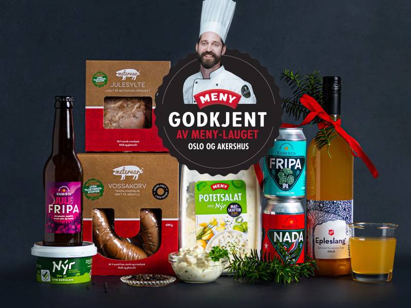 Et utvalg av julemat og godteri, inkludert pølser, potetsalat, sjokolade og brus, på et bord.