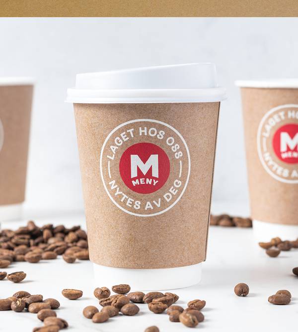 Kopp laget av resirkulert emballasje med logo og tekst om bærekraft, omgitt av kaffebønner på en hvit bakgrunn.