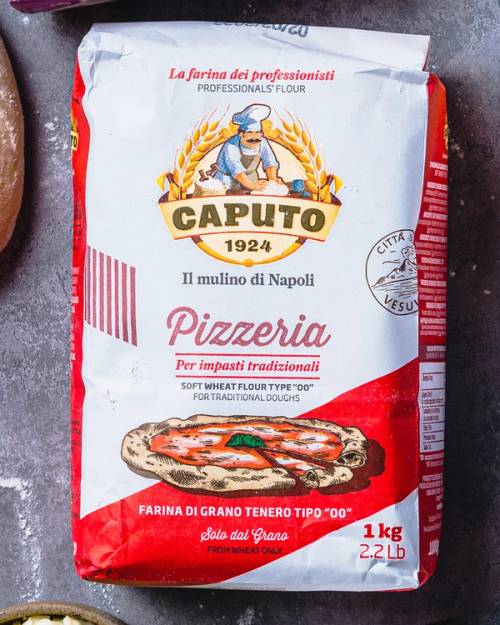 En 1 kg pose med pizzamel fra Caputo, med bilde av en pizza og tekst på norsk og italiensk.