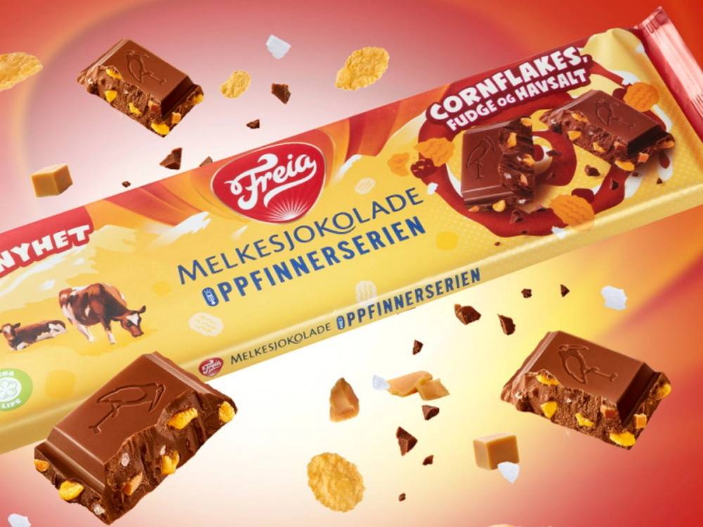 En sjokoladeplate med cornflakes, fudge og havsalt, omgitt av små sjokoladestykker og cornflakesbiter.