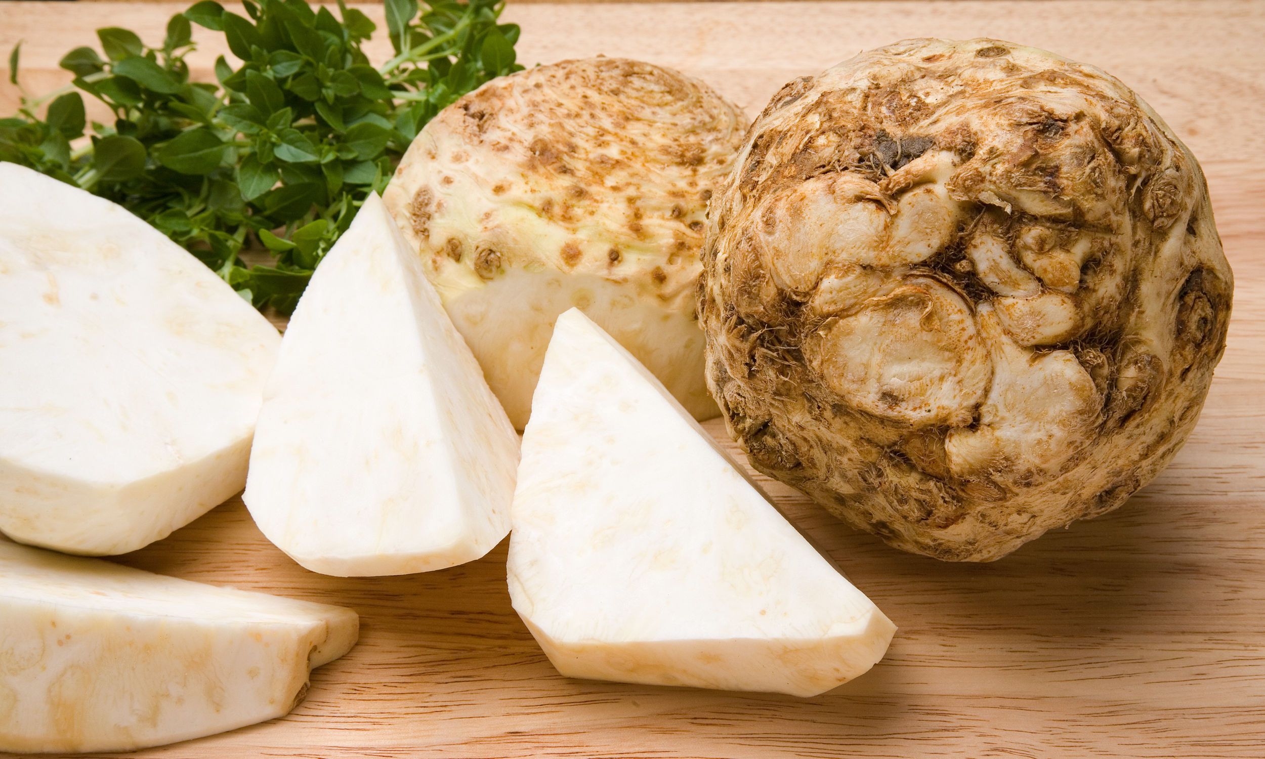 Sellerirot og selleristenger på et skjærebrett, klare til å bli brukt i matlaging.