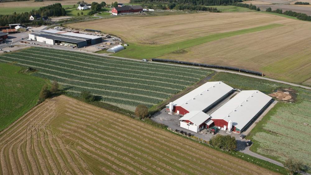 Luftfoto av gårdsanlegg omgitt av store åkre.