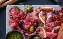 Et fat med spekemat, ost, grønnsaker og brød, klar for helgekos.