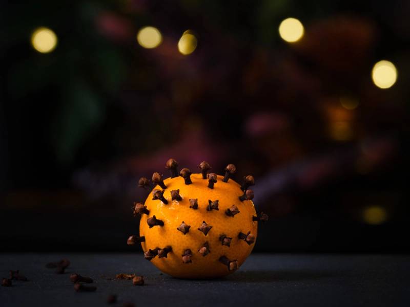 En nellik på en kalender, med blomster og lys i bakgrunnen.