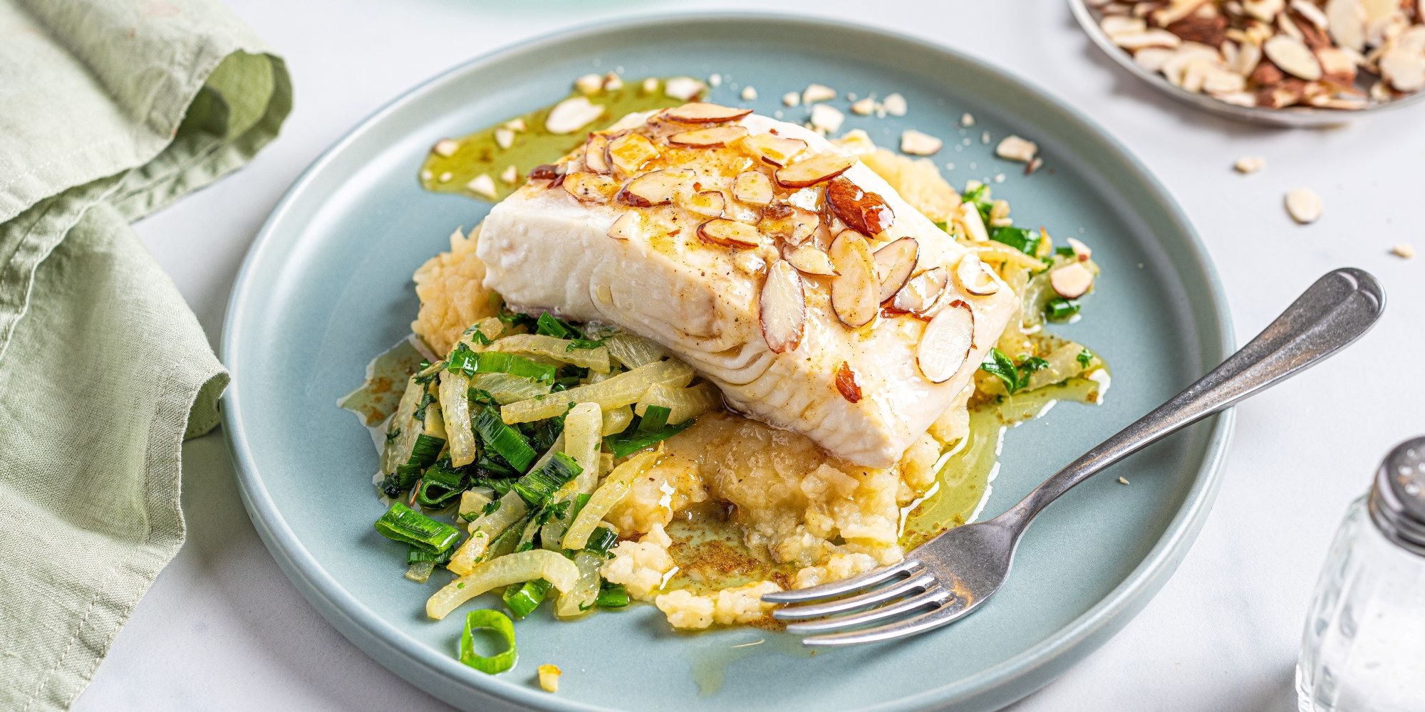 Kveitefilet servert med potetstappe og grønnsaker på en blå tallerken